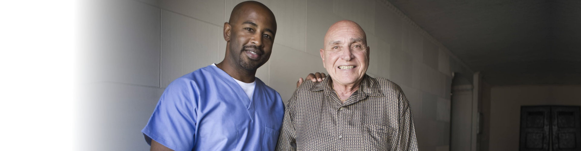 a caregiver and a senior man smiling